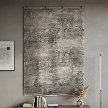 This rug features an understated abstract design in cream and grey tones, finished with a defined geometric border along the edges. The pile is intentionally low and soft, giving it a smooth, premium feel underfoot. It delivers a clean, high-quality look using simple, neutral colors.