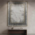 Modern abstract area rug in grey and beige tones styled in a minimalist living room with a grey sofa and wooden credenza.
