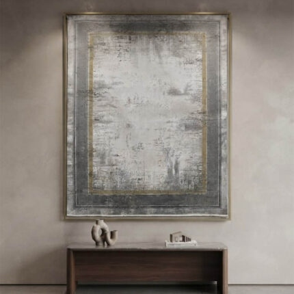 Modern abstract area rug in grey and beige tones styled in a minimalist living room with a grey sofa and wooden credenza.