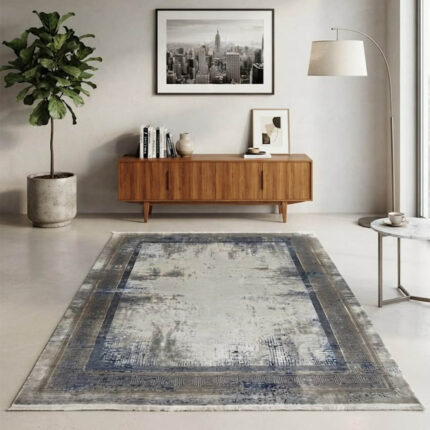 Modern abstract area rug in grey and beige tones styled in a minimalist living room with a grey sofa and wooden credenza.