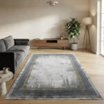 Modern abstract area rug in grey and beige tones styled in a minimalist living room with a grey sofa and wooden credenza.