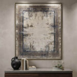 Modern abstract area rug in grey and beige tones styled in a minimalist living room with a grey sofa and wooden credenza.